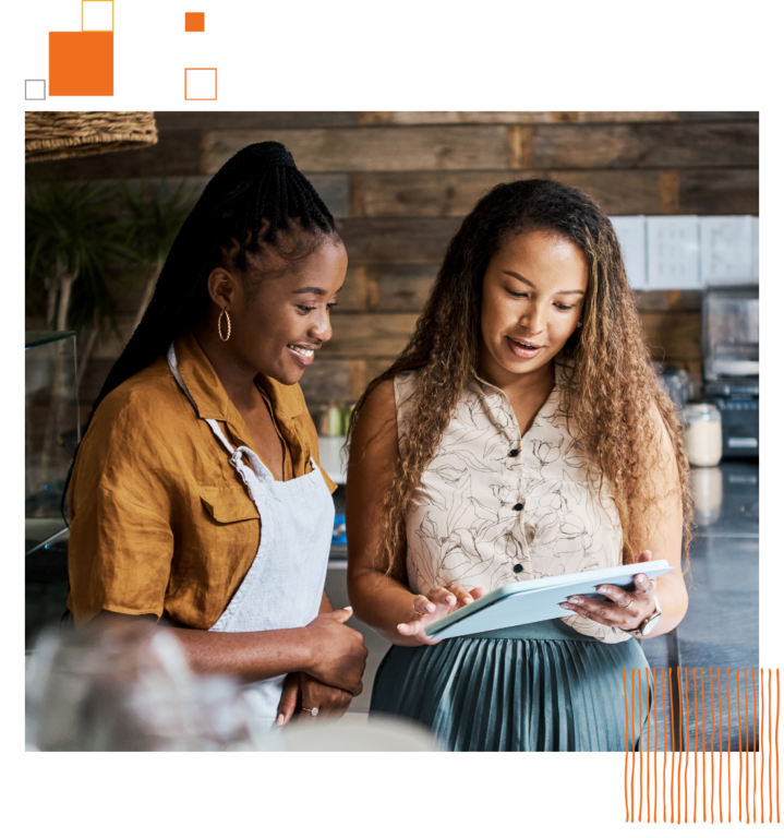 two women in restaurant looking at tablet