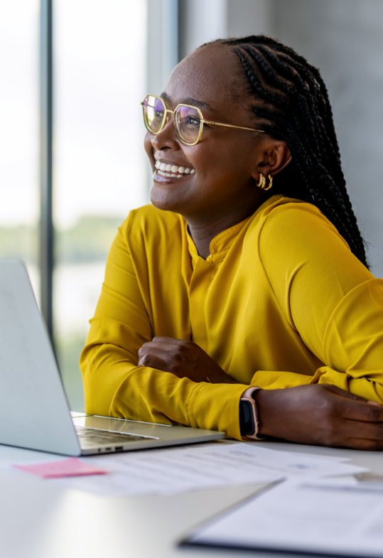 smiling woman sitting in front of laptop