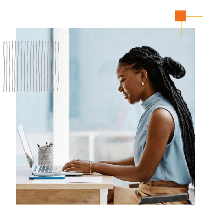 woman sitting at desk typing on laptop