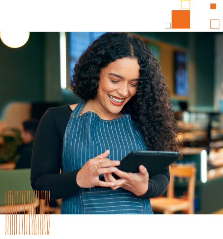 smiling woman in a cafe looking at a tablet